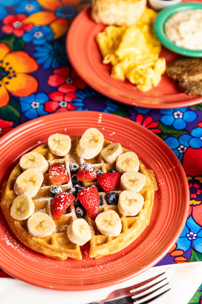 Waffle topped with bananas, strawberries and blueberries